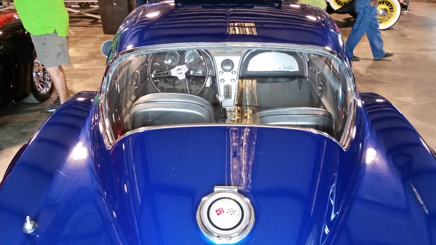 blue car at an auto show with other vehicles
