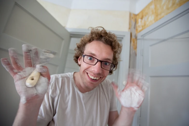 a young man making funny faces and holding up a doll