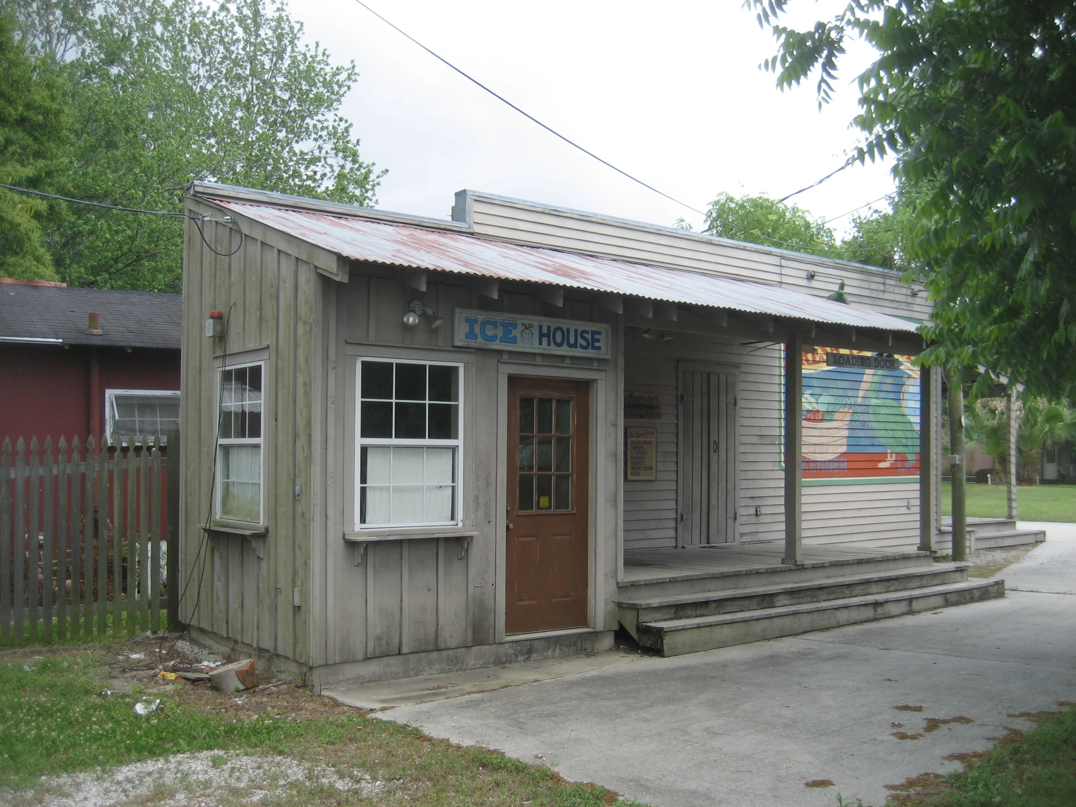 a small building with windows sitting next to trees