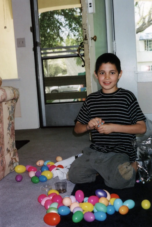 a  sitting in a room surrounded by balloons