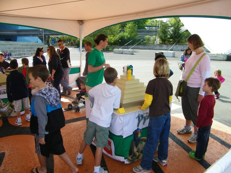 children and adults gathered around a green cake display