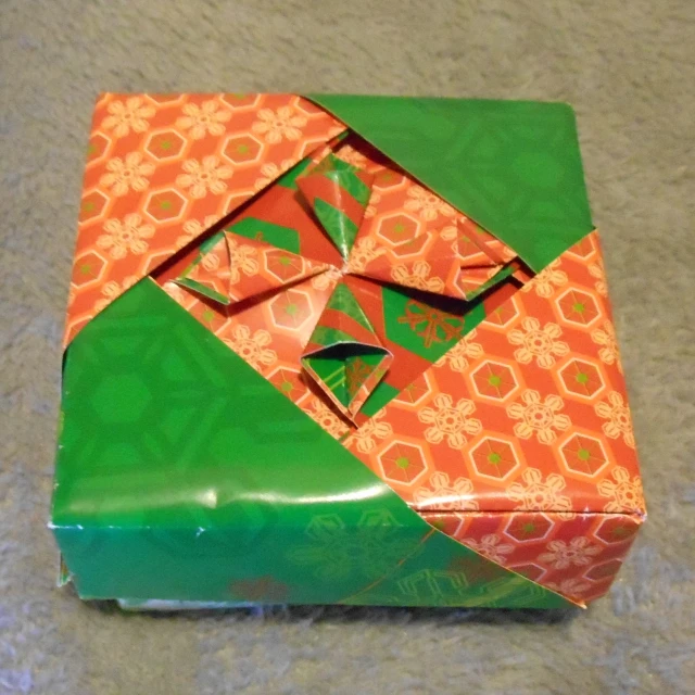an orange and green gift box sitting on a table