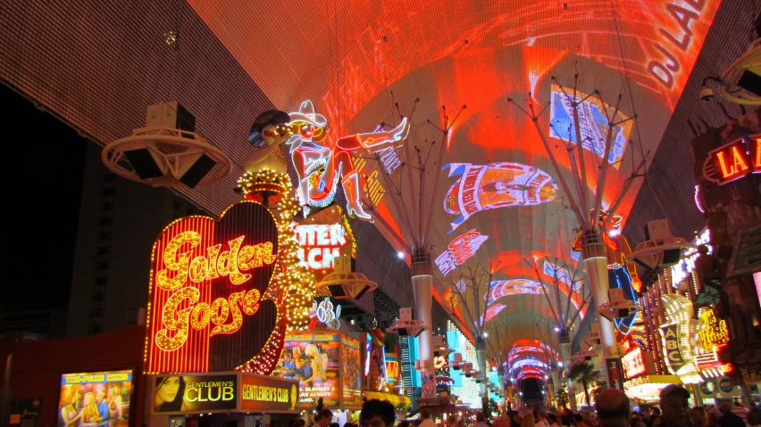 a crowded city street is lit up with brightly colored lights