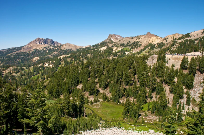 there is a small hill in the mountains that has pine trees