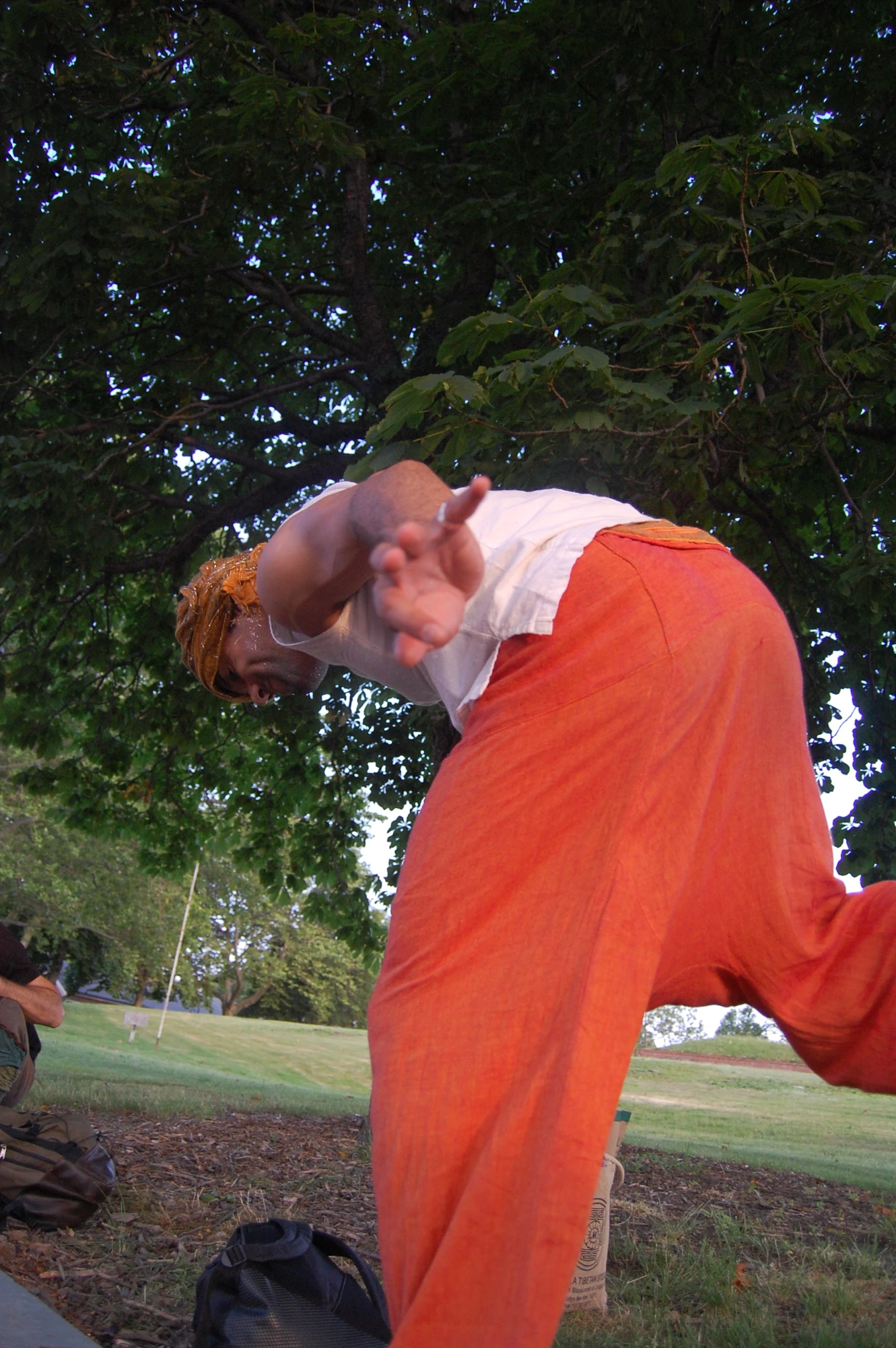 a man in orange pants standing near a bench