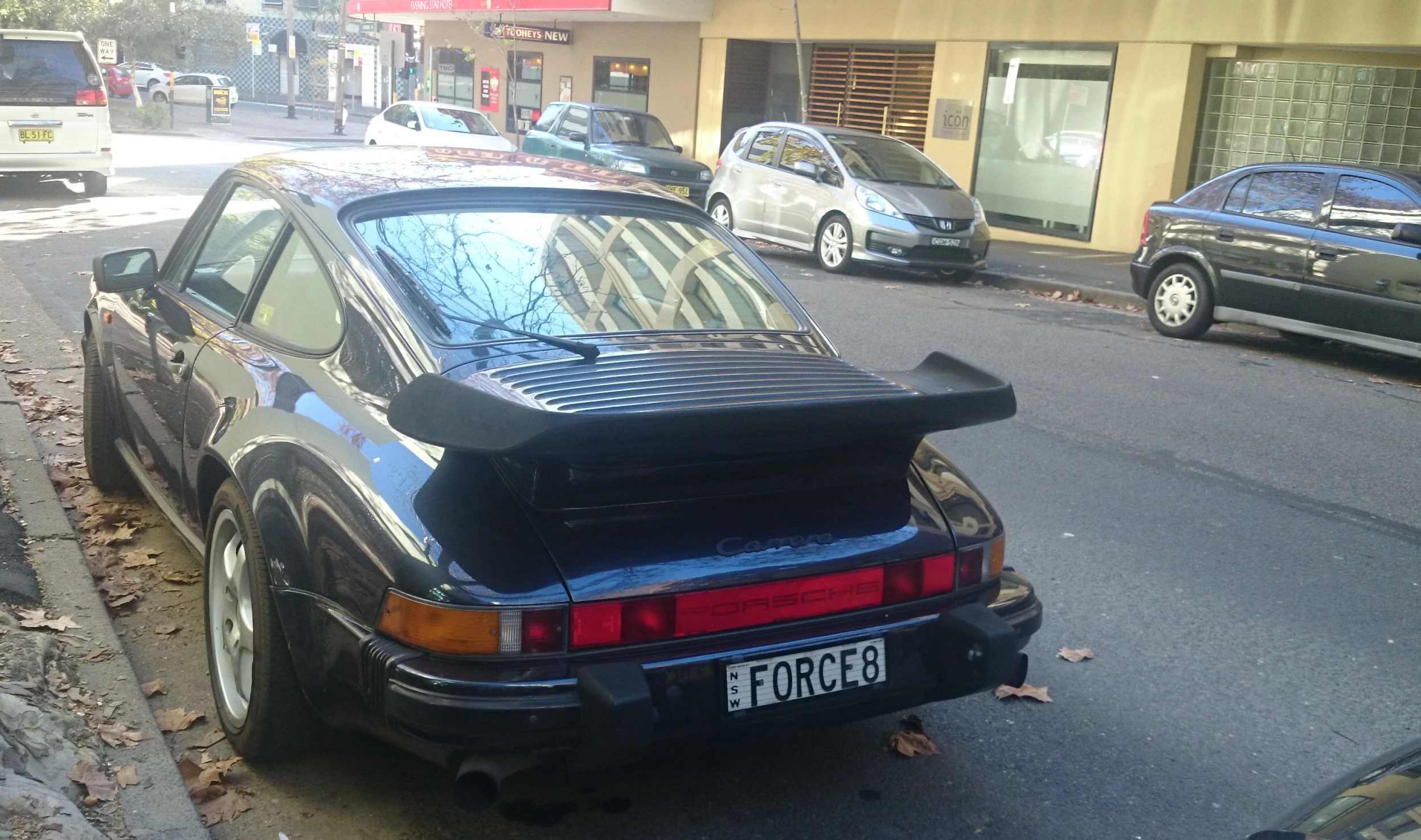 a car sitting on a street with the hood down