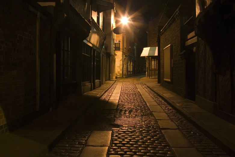a dark narrow cobbled alley in an alleyway