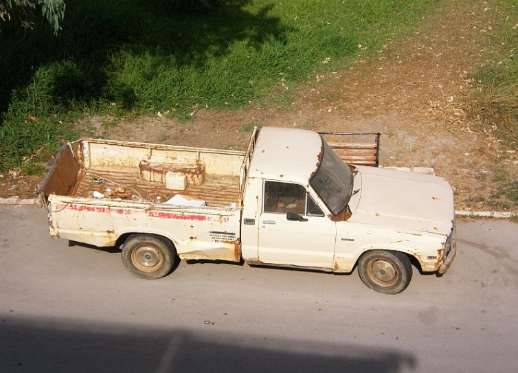 an old pickup truck with a white bed parked in a parking lot