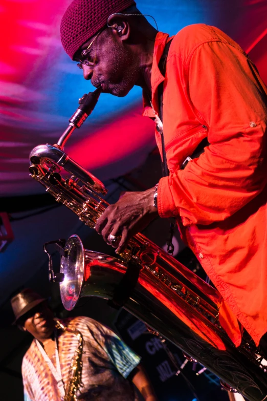 a man plays the saxophone while a crowd watches