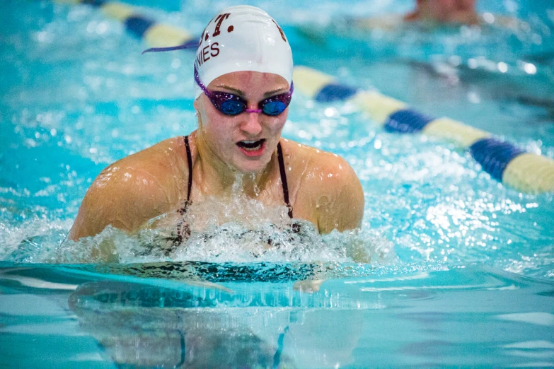 a women's swimming team wearing glasses in the water