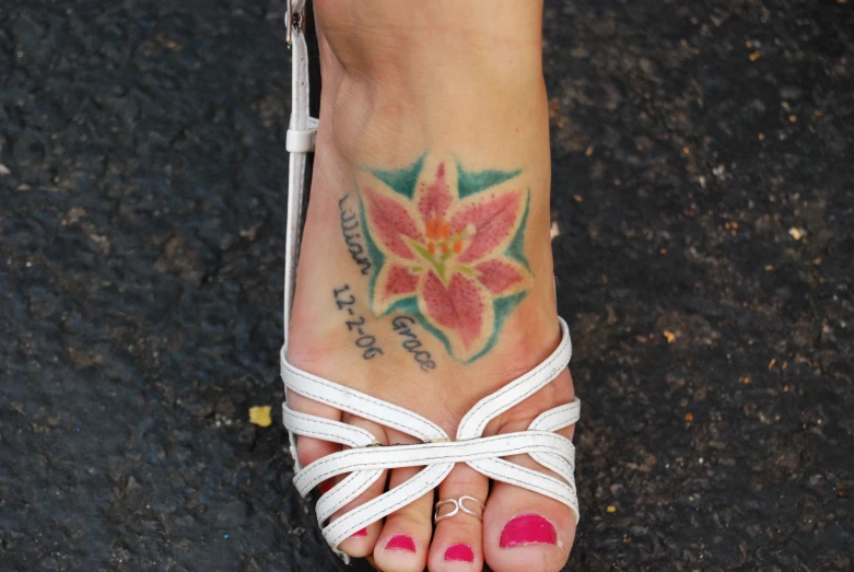 a very pretty girl wearing white sandals and a flower tattooed on her left ankle