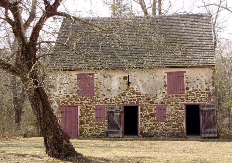 an old brick building sitting next to a tree