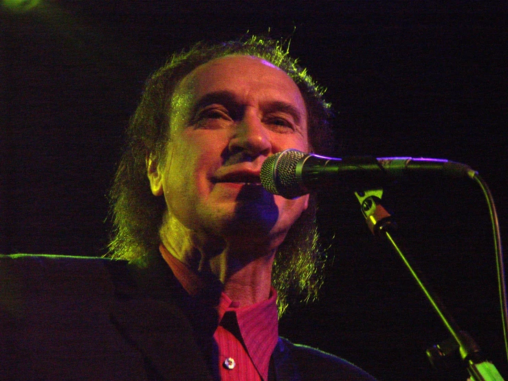 a man on stage in front of a microphone