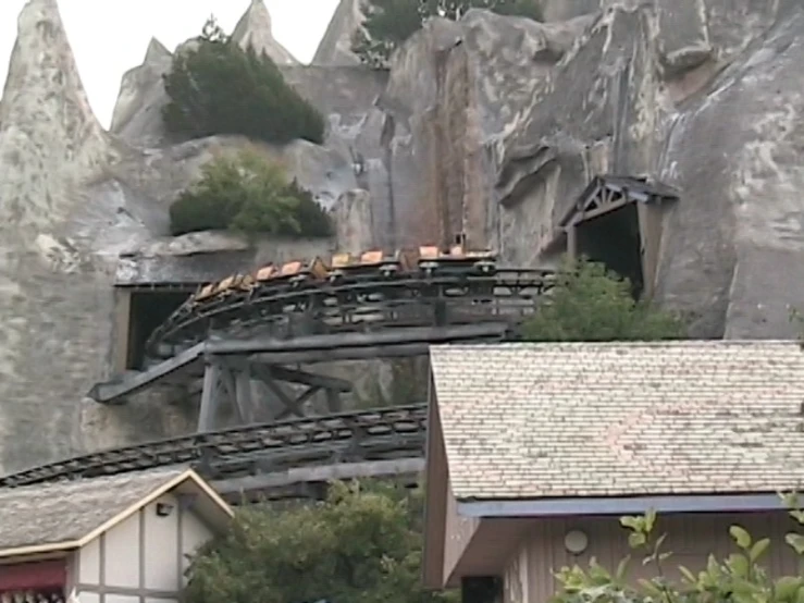 several people riding the top of a large roller coaster