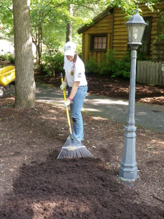 a woman uses a shovel to clear dirt off the ground