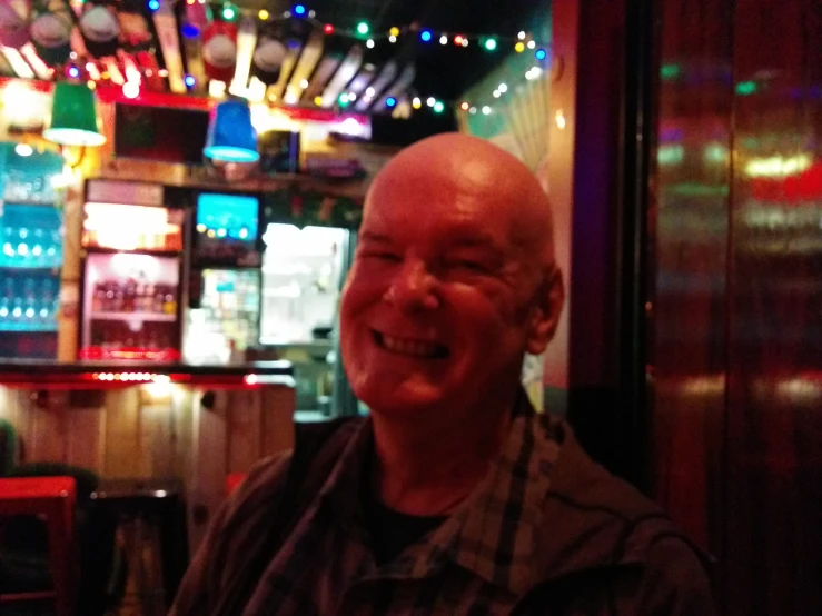 a bald man sitting at a table in a restaurant