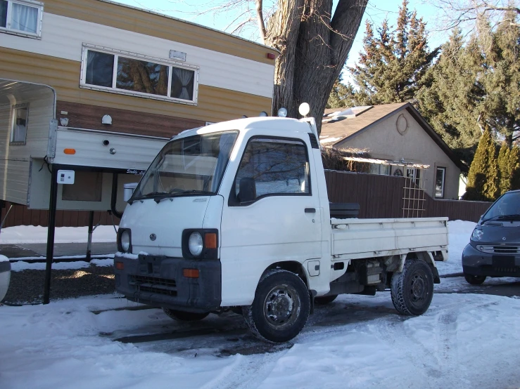 white truck sitting on the side of a snowy road