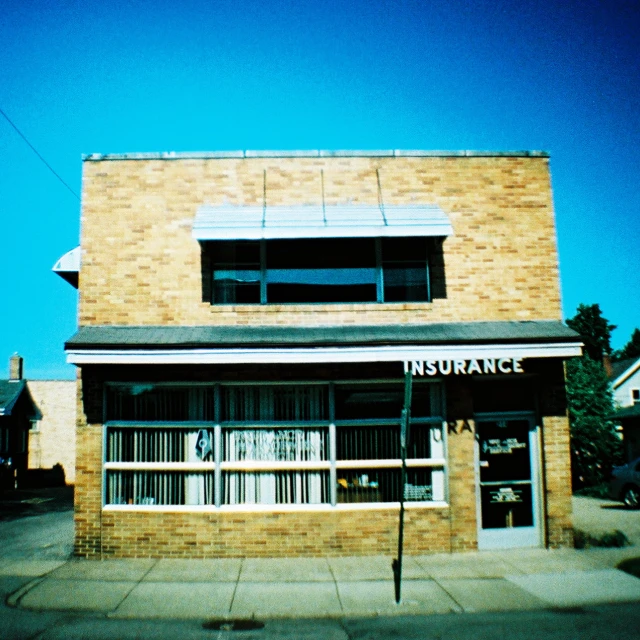 an orange brick building with an air vent above the top