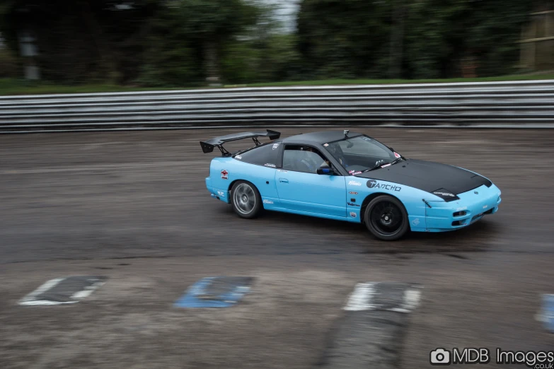 blue sports car is parked in an empty lot