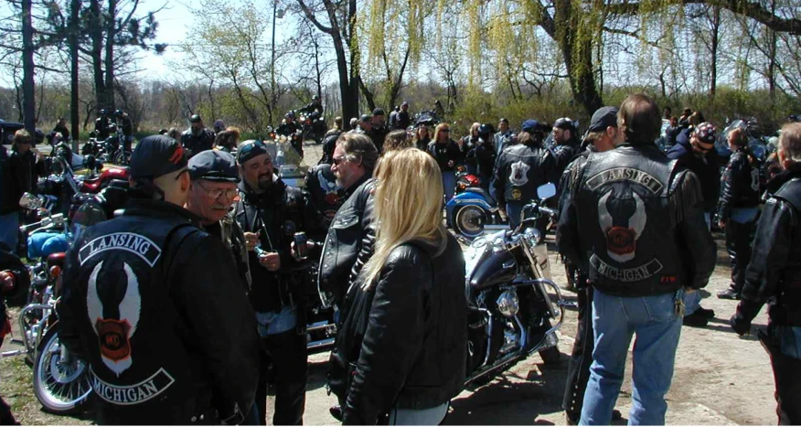 a bunch of people standing around near motorcycles