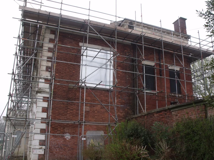 scaffolding surrounding an old brick building in the uk