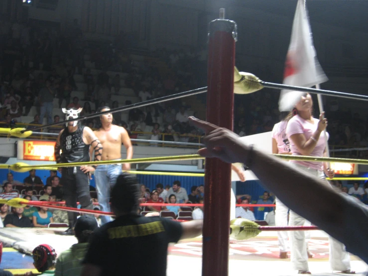 a woman and man in ring surrounded by other wrestlers