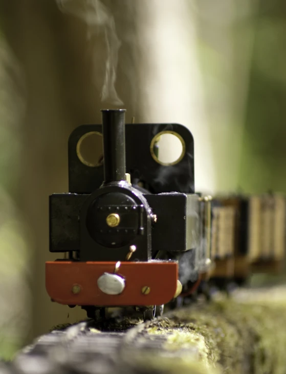 a toy train on tracks is blowing smoke