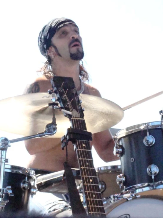 a man playing drums on stage while looking at the audience