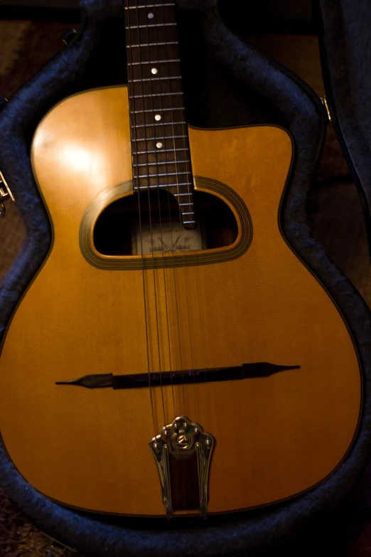the acoustic guitar is shown laying on its case
