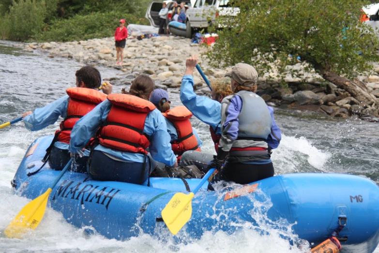 group of people riding rafts down a river