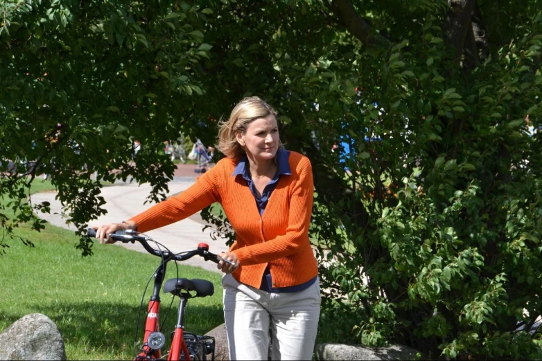 a woman is riding her bike in the park