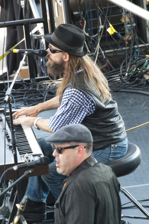 two men play the piano on stage together