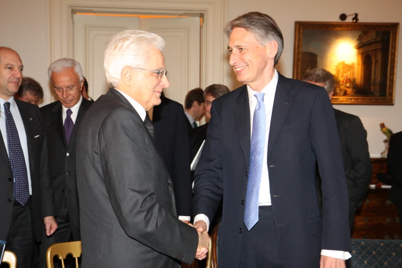 two men are shaking hands at a business meeting