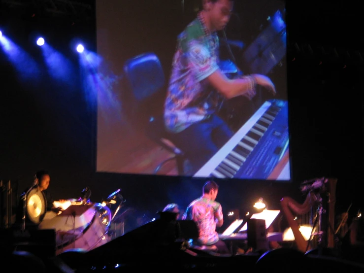 a large screen is displaying a live concert