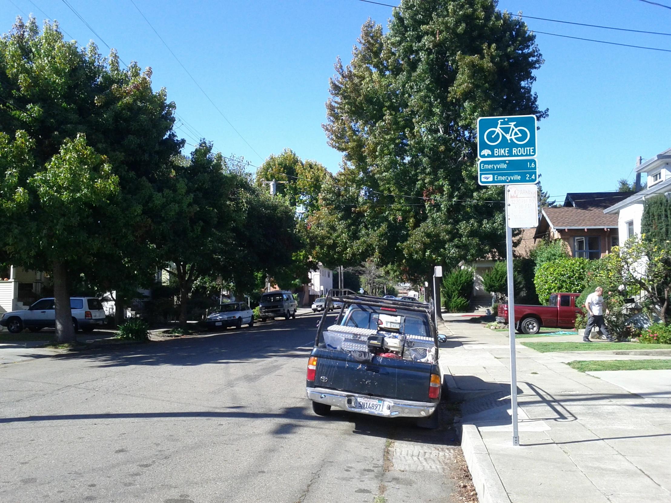 a car parked next to a street sign on the side of the road