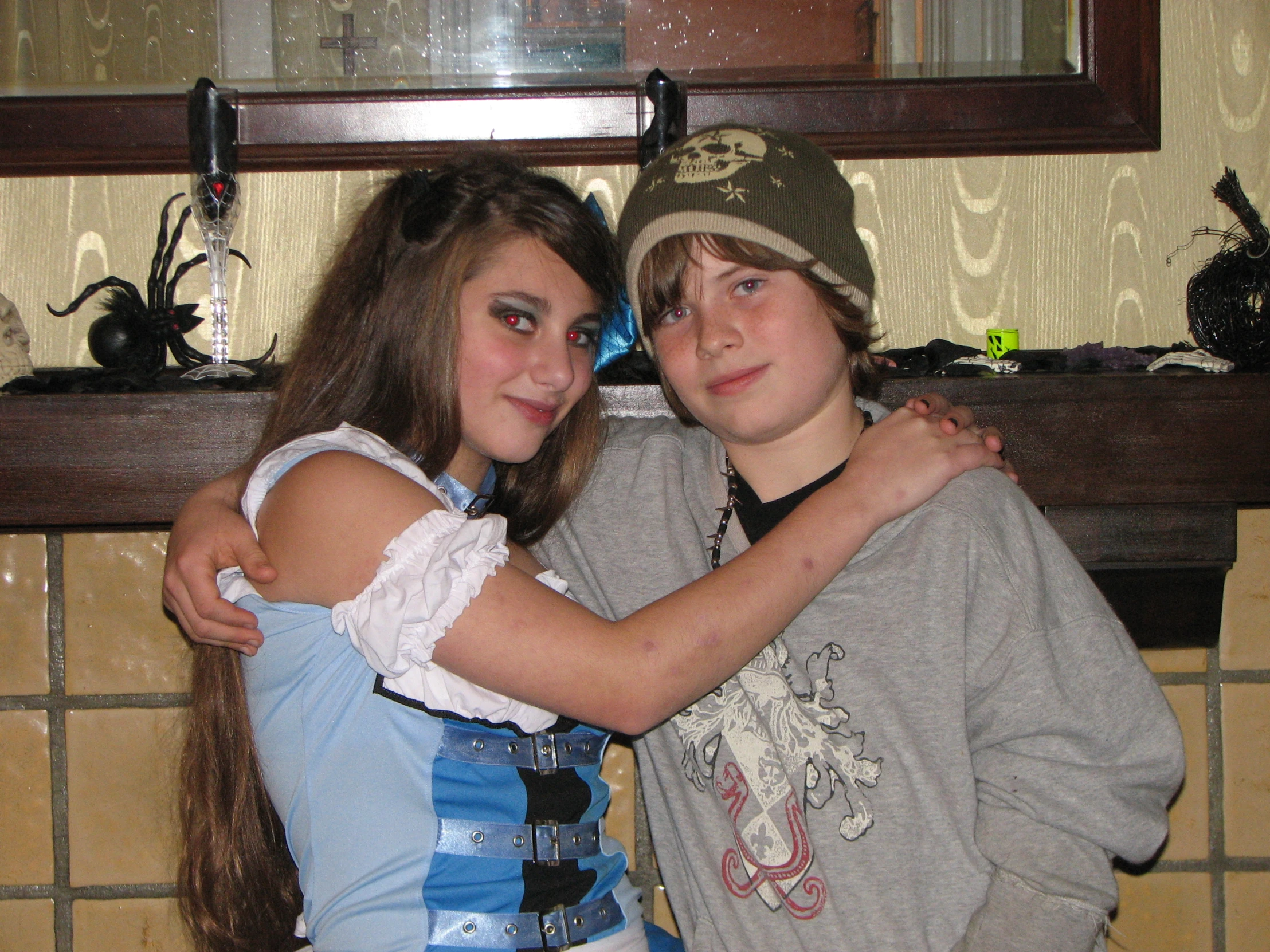 two young people emcing in front of a fireplace