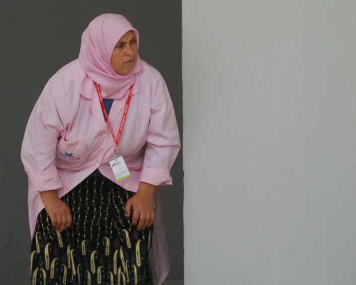 a woman wearing a pink shirt and a skirt