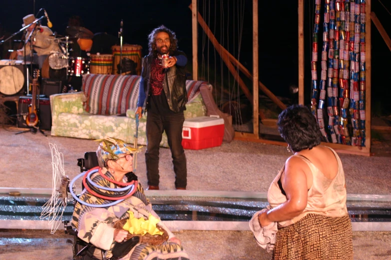 a man in headdress standing next to a woman on stage