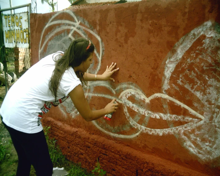 a woman painting on the side of a wall