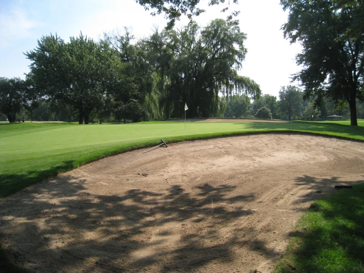 a grassy course with dirt and trees surrounding it