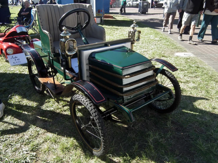 the old cars are parked on the grass in the park