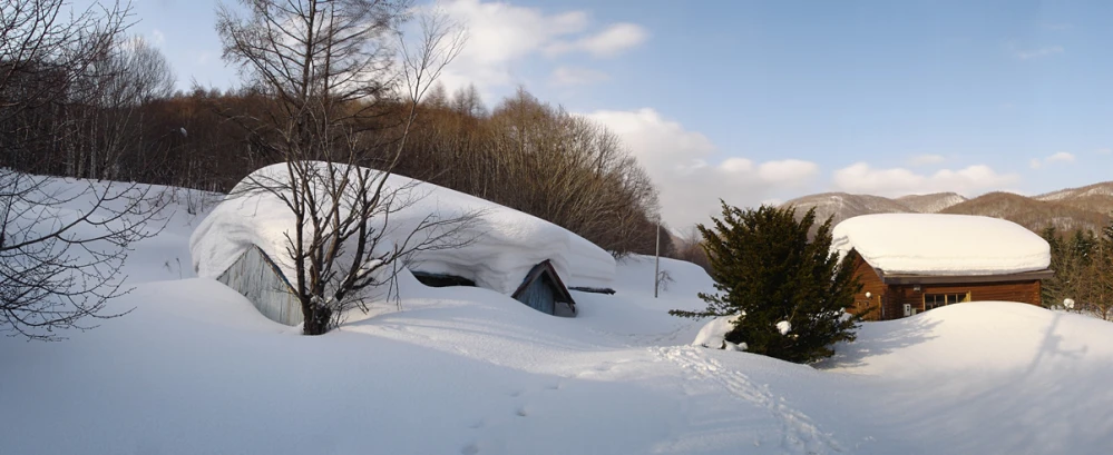 a car covered in snow parked at the side of a hill