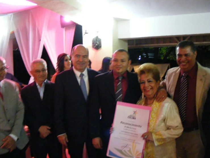 group of smiling people at a celetion with large sign