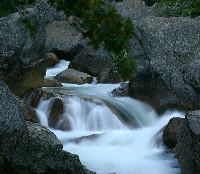 small river with rushing water among many boulders