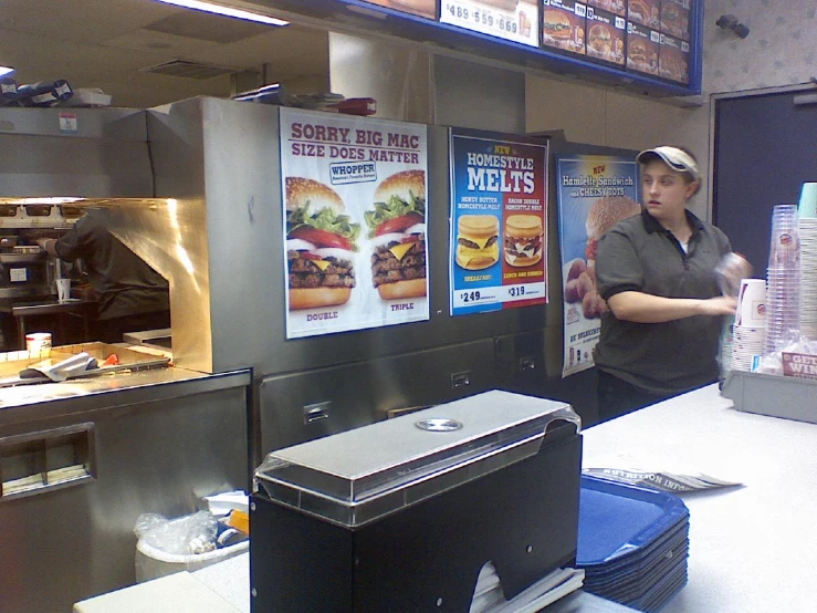 a restaurant worker serving customers food at a fast food station