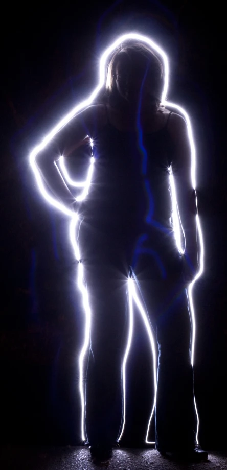 woman standing under the dark in front of blue lights