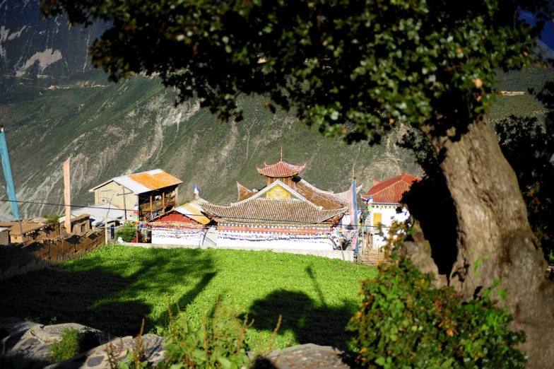 a house with red tile roof near a large hill