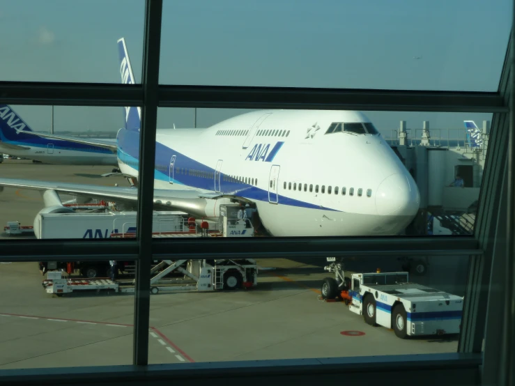 an airplane is sitting on the tarmac with a service worker walking toward it