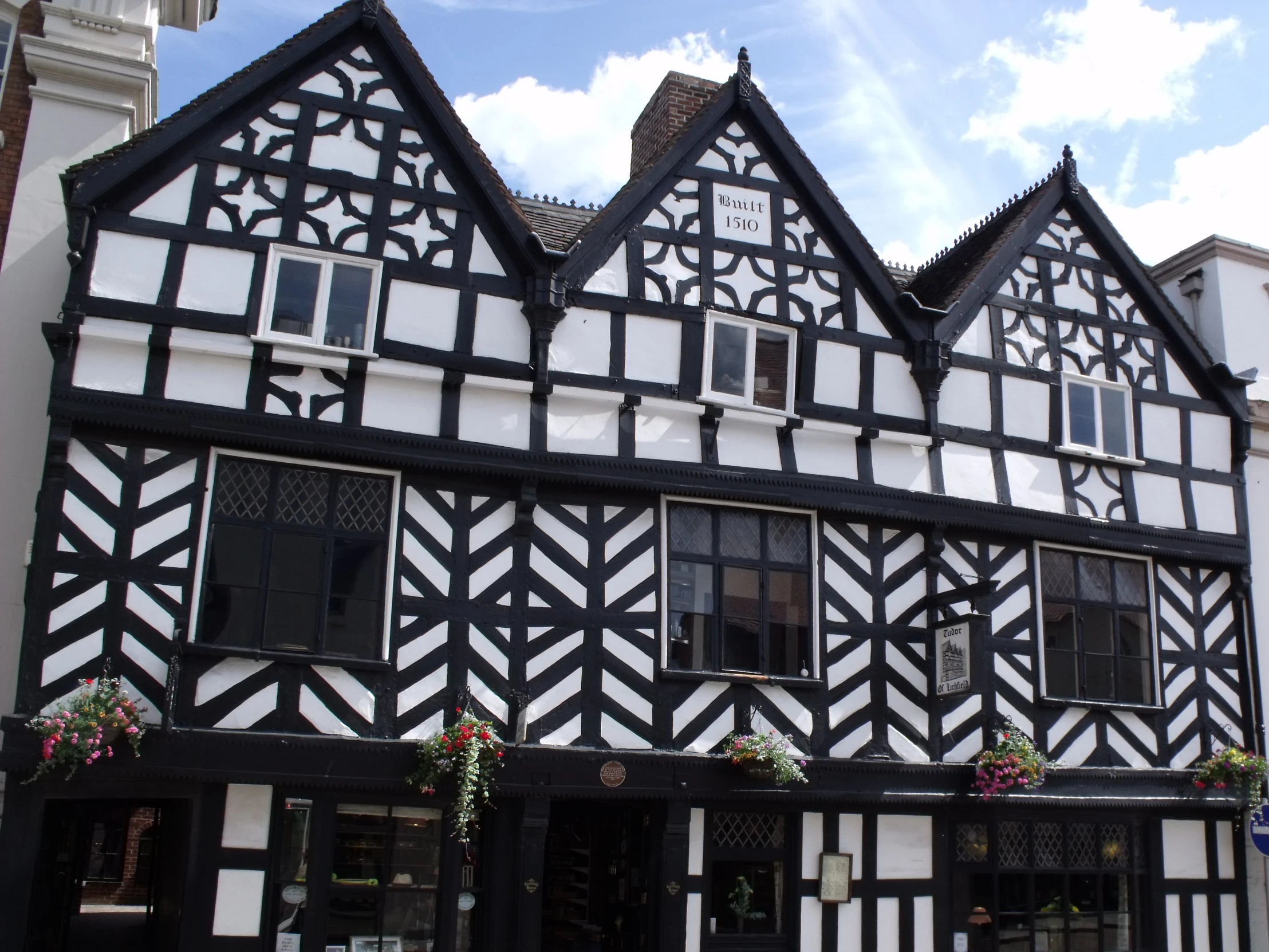 a white and black building that has flowers on the side