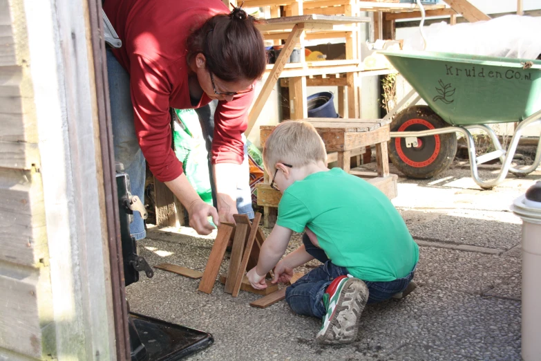 two children playing on wooden blocks in a yard